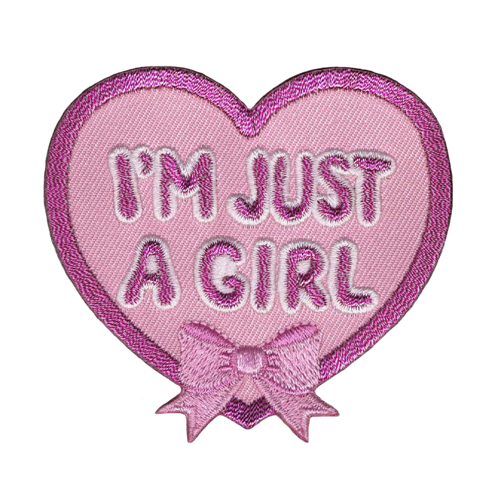 Sydämenmuotoinen kangasmerkki, rusetti, teksti: I'm just a girl.